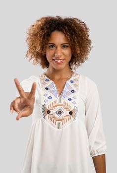 Beautiful African American woman making a sign of peace and love