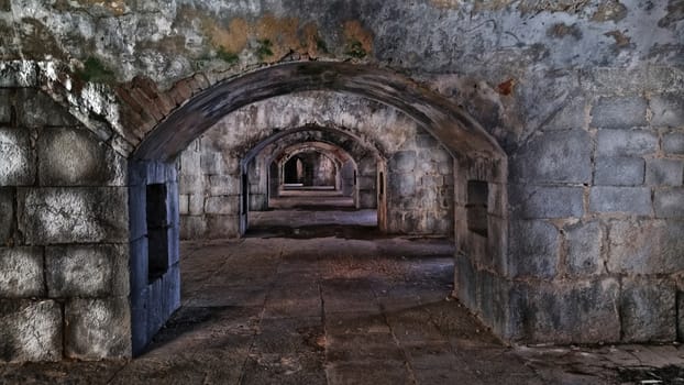 dark casemates inside the old fort. Archs made of stone stretch deep into the fortress