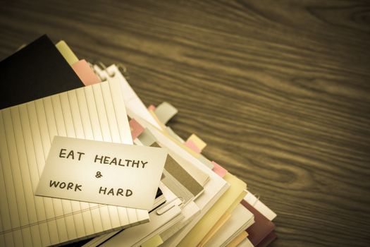 Eat Healthy Work Hard; The Pile of Business Documents on the Desk