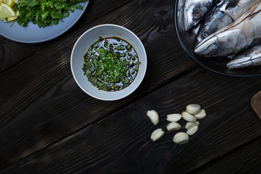 Fish with herbs and vegetables on a wooden table