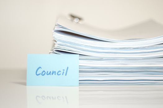 Council; Stack of Documents on white desk and Background.