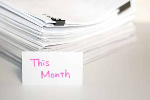 This Month; Stack of Documents on white desk and Background.