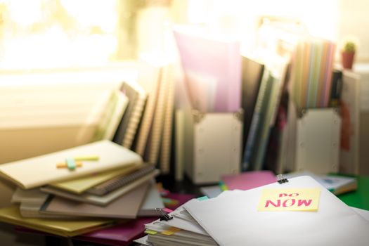 Do Now; Stack of Documents. Working or Studying at messy desk.