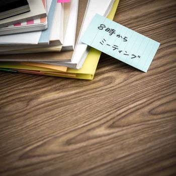 Meeting 8 PM; The Pile of Business Documents on the Desk