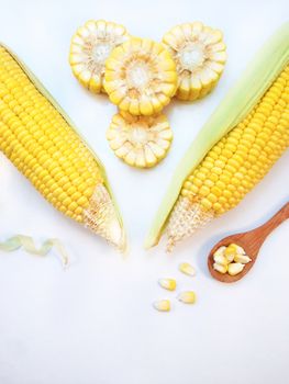 Corn with wooden spoon on white background