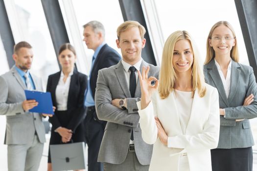 Successful young business people showing ok sign
