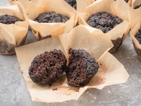 Gluten-free vegan chocolate muffins with beetroot, almond powder, buckwheat flour and karob or cocoa . Homemade cupcakes on gray concrete background with copyspace