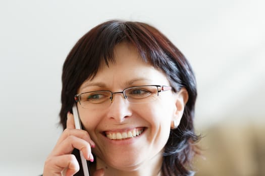 beautiful middle-aged smiling housewife woman without makeup call by phone