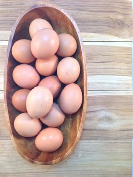 Eggs in wooden bowl on wooden background