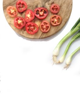 Tomatoes slices on cutting board with spring onion