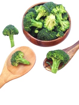 Broccoli in wooden bowl and wooden spoon on white background