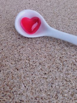 Mini heart jelly  in white little spoon on plywood