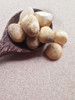 Straw mushroom with wooden spoon on plywood background