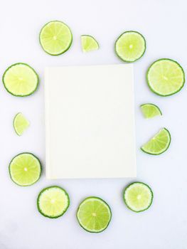 diary with lime slice on white background