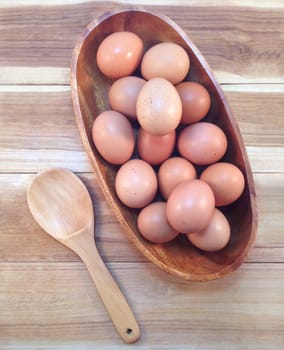 Eggs in wooden bowl on wooden background