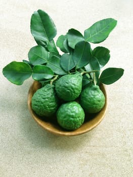 Kaffir Lime or Bergamot in wooden bowl on white background