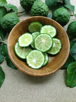 Kaffir Lime or Bergamot in wooden bowl on plywood background