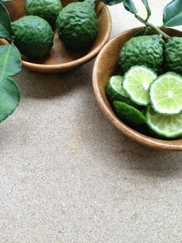 Kaffir Lime or Bergamot in wooden bowl on plywood background