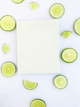 diary with lime slice on white background