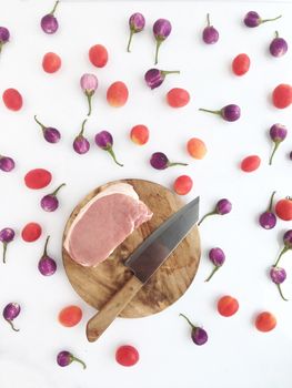 Pork on cutting board with tomatoes and  Thai eggplants