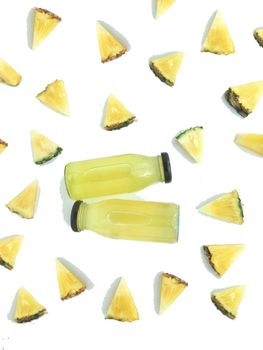 Fresh and cold pineapple drink among triangular piece of pineapple