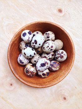 Quail eggs in wooden bowl