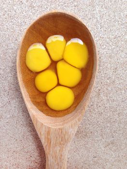 Quail eggs in wooden spoon on plywoos background