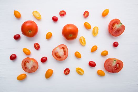 variety tomatoes on white wooden background.