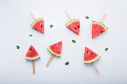 Watermelon slice popsicles on white background
