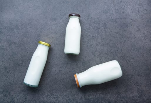 Milk bottle on dark stone background. Top view with copy space.