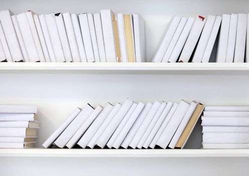 white shelf with books without inscriptions