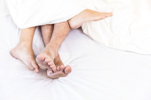 young sexy couples in love lying in bed in hotel, embracing on white sheets, close up legs, romantic mood