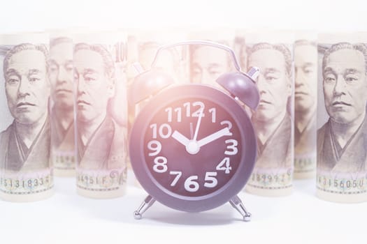 Classic Clock On Roll Of Yen Banknote, Concept And Idea Of Time Value And Money, Business And Finance Concepts, Money market in Asia