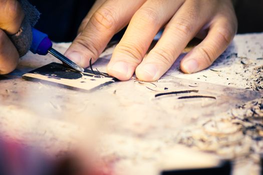 Hands Of Craftsman Carve With Engraving Tool On Table Workbench In Carpentry, Work Learning Craftsman Profession In Art Class.