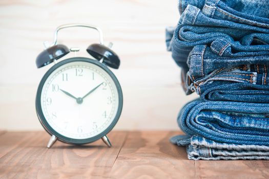 Stack Of Jeans And Classic Timepieces On Old Wood Flooring,
Fashion Concept With Time
