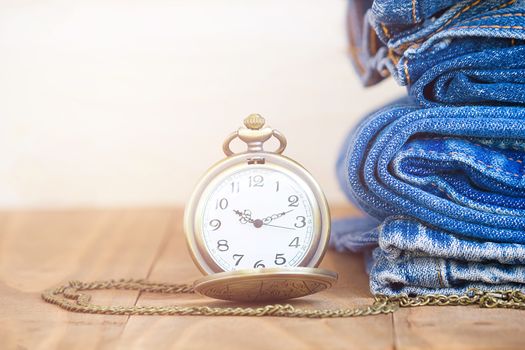 Stack Of Jeans And Classic Timepieces On Old Wood Flooring,
Fashion Concept With Time
