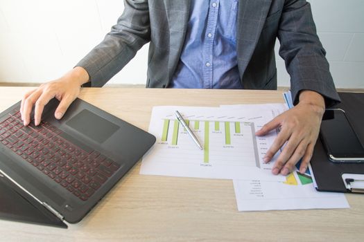 Business man working  with laptop and documents on wood table