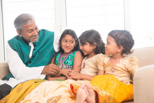 Portrait of happy Indian family bonding at home. Asian father and children indoors lifestyle.