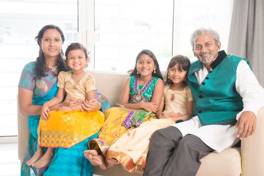 Portrait of happy Indian family in traditional clothes at home, smile at camera. 