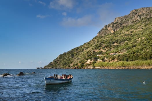 Panorama on the ocean and a traditional fishing boat in the village of Paralia in western Crete