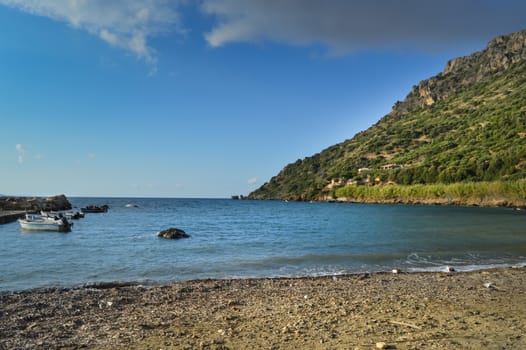 Panorama on the ocean and a traditional fishing boat in the village of Paralia in western Crete