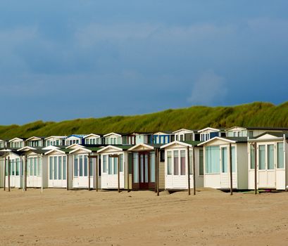 Beach Houses in Dunes on North Sea coast against Blue Sky in Netherlands Outdoors