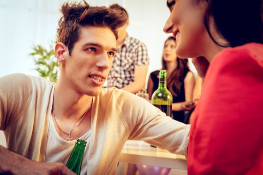 Young cute smiling boy on home party. She is looking at his boyfriend. Selective focus.