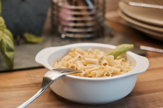 Delicious and fresh pasta on white plate on wooden board in the kitchen. Cooking concept.