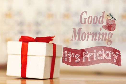 good morning it's friday message with white gift box with red ribbon on wood background