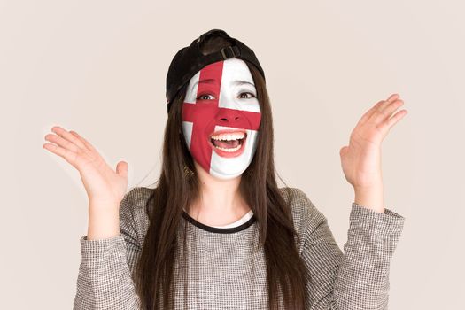 Excited fan England in face paint cheering against England flag