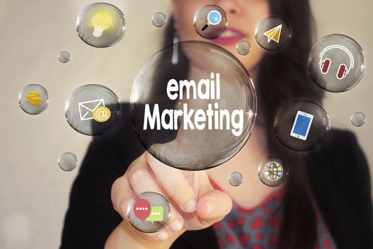 Portrait of a beautiful young woman pointing her finger to Email Marketing in transparent bubble