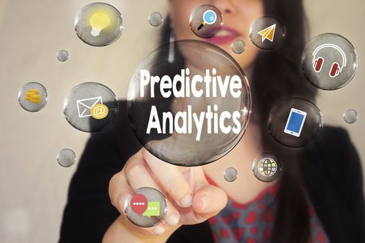 Portrait of a beautiful young woman pointing her finger to Predictive Analytics in transparent bubble