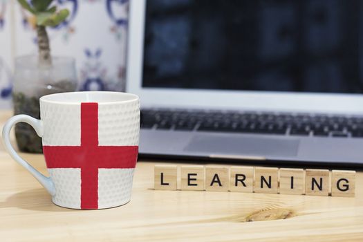 english,England  flag painted on cup coffee, letter wood learning,gray laptop
