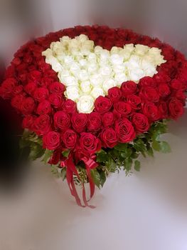 a large bouquet of red and white roses in the form of heart on light background blurred. A gift on Valentine's Day February 14